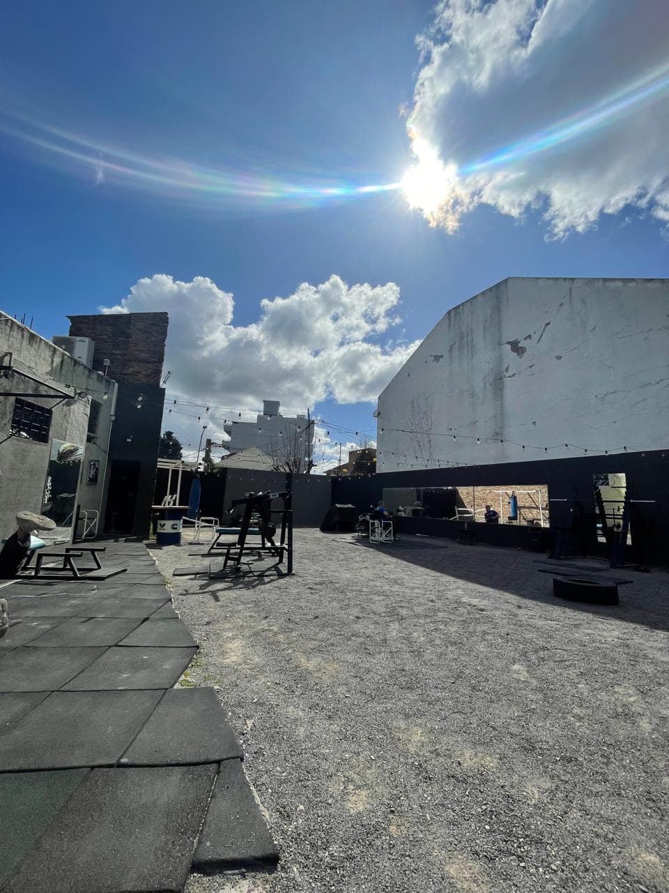Vista del patio abierto del gimnasio con espejos y máquinas de fuerza